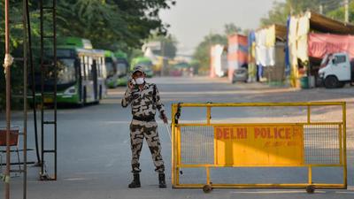 A security person keeps vigil at Singhu Border in New Delhi. Autopsy report said the Dalit man died due to excessive bleeding due to deep wounds. (PTI)