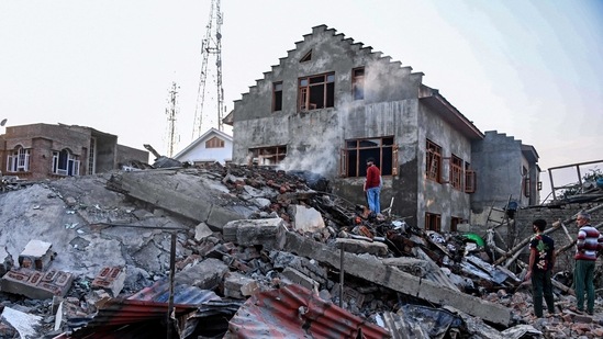 Residents stand amid the debris of a house damaged in a gun battle, in the Drangbal area of Pampore on Saturday. (AFP) Residents stand amid the debris of a house damaged in a gun battle, in the Drangbal area of Pampore on Saturday. (AFP)