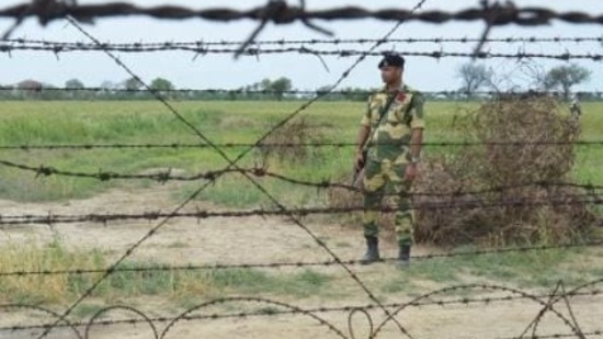 A BSF jawan patrolling the barbed fence on the Indo-Pakistan border in Punjab.