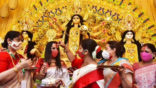 Married women apply vermillion (Sindur) on each other as part of 'Sindur Khela' ritual on the last day of the Durga Puja festival, in Kolkata.(ANI)
