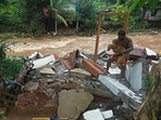 A man carries a dog amid the debris of his damaged house after flash floods caused by heavy rain at Thodupuzha in Kerala. (AFP File Photo) A man carries a dog amid the debris of his damaged house after flash floods caused by heavy rain at Thodupuzha in Kerala. (AFP File Photo)
