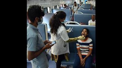 A healthcare worker collects a swab sample of a girl for the COVID-19 test inside a train compartment, in Bengaluru (Shashidhar Byrappa)