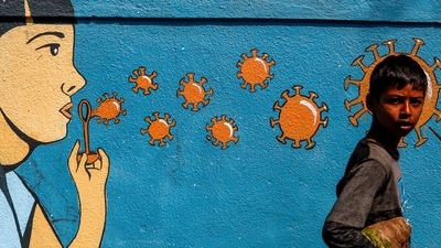 A boy walks past a graffiti amidst the spread of the coronavirus disease (Covid-19) on a street in Navi Mumbai. (Reuters file photo)