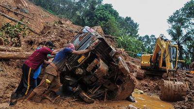 Rescue workers push an overturned vehicle stuck in the mud after a landslide in Kerala’s Kokkayar, on Sunday. Kerala rain toll has increased to 24. (AFP) Rescue workers push an overturned vehicle stuck in the mud after a landslide in Kerala’s Kokkayar, on Sunday. Kerala rain toll has increased to 24. (AFP)