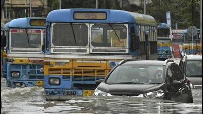 Vehicles wading through a waterlogged road during rain in Kolkata on Saturday. (PTI PHOTO.)