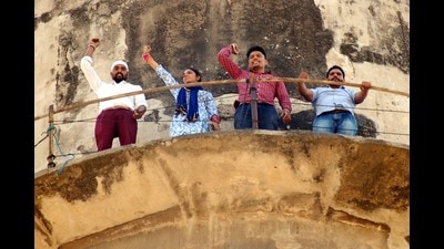 Teachers protesting on top of a water tank in Mohali on Sunday. (HT photo)