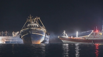A fishing boat with migrants docked at the port of the Sicilian island of Lampedusa, southern Italy, late Monday. (Sea-Watch.org/David Lohmueller via AP)