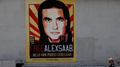 A woman walks by a mural in support of the liberation of Colombian businessman and envoy Alex Saab. (REUTERS)