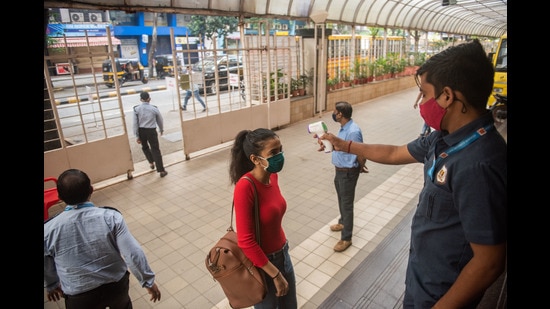 Security staff checks temperature of a student after schools reopen with all Covid-19 protocols in place in Mumbai on October 04. (Pratik Chorge/HT PHOTO)