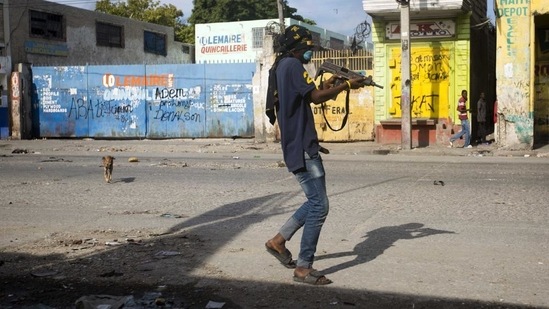 Haiti: In this Nov. 21, 2018 file photo, an armed civilian carries a weapon on during a shootout between rival gangs(File Photo / AP)