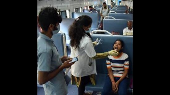 A healthcare worker collects a swab sample of a girl for the COVID-19 test inside a train compartment, in Bengaluru (Shashidhar Byrappa) A healthcare worker collects a swab sample of a girl for the COVID-19 test inside a train compartment, in Bengaluru (Shashidhar Byrappa)