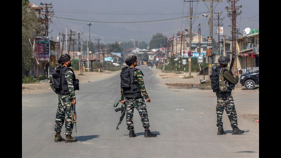 Soldiers stand guard on a road leading towards the site of a gunfight in Kashmir (AP)