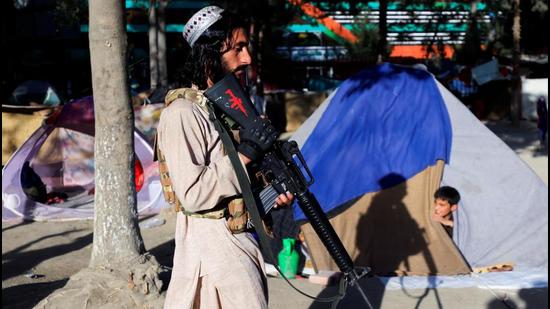 A Taliban fighter walks past the tent of a displaced family fleeing the violence in their province at Shahr-e Naw park in Kabul in Afghanistan. (Image used for representation). (REUTERS PHOTO.)