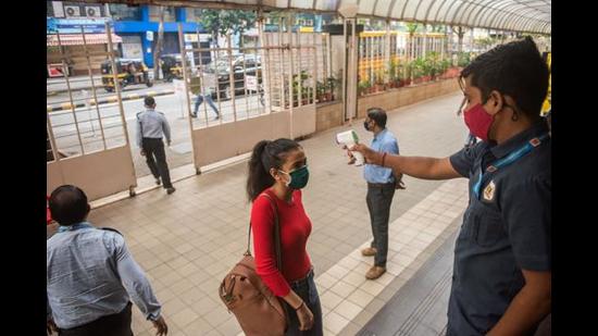 Security staff checks temperature of a student after schools reopen with all Covid-19 protocols in place in Mumbai on October 04. (Pratik Chorge/HT PHOTO)