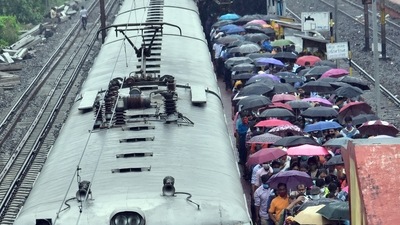 Passengers are seen with umbrellas at a train station in Kolkata. (ANI Photo) Passengers are seen with umbrellas at a train station in Kolkata. (ANI Photo)