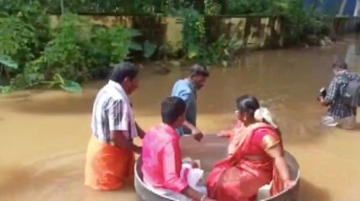 A viral video is floating around the internet, in which the bride Aishwarya and the groom Akash are seen sitting in a round cooking pot, which is being pushed by two men. (ANI on Twitter) A viral video is floating around the internet, in which the bride Aishwarya and the groom Akash are seen sitting in a round cooking pot, which is being pushed by two men. (ANI on Twitter)