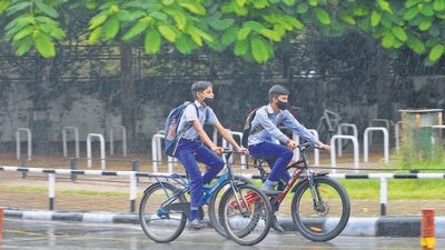 Schoolchildren cycling back home on a rainy Monday afternoon in Chandigarh. (Ravi Kumar/HT)