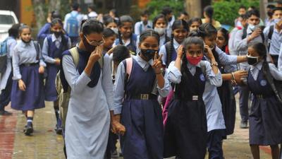 Students wearing face masks while leaving for home at the Sector-45 government school in Chandigarh on Monday. (Keshav Singh/HT)