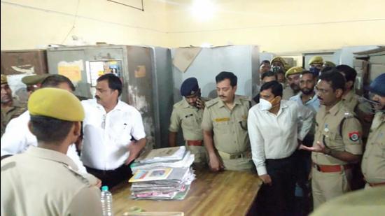 Investigating officials at the site where a lawyer was shot dead by a colleague, in a district court in UP on Monday.