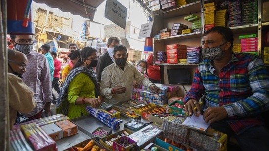 Lakshmi Puja is marked on the second day of Diwali, which is also the darkest day of the traditional month. In this photo, people buy firecrackers from a shop ahead of the festival.(HT Photo/Amal KS)