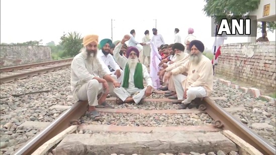 Farm law protestors sit on the railway track at Devi Dasspura village in Amritsar following the farmer's union call for 'Rail Roko Andolan'.(ANI)
