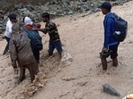Police personnel rescue stranded devotees who were going to Shri Maa Poornagiri Darshan, amid heavy rains, in Uttarakhand on Monday.
