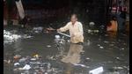 A commuter struggles to cross a waterlogged road after heavy rainfall, in Agra on Monday. (ANI Photo)