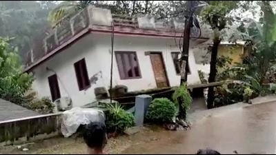 People watch a house being washed away by a river due to strong current after heavy rain at Kottayam in Kerala. (REUTERS PHOTO.)