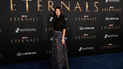 Director Chloe Zhao smiles for the paparazzi at Eternals premiere. (REUTERS) 