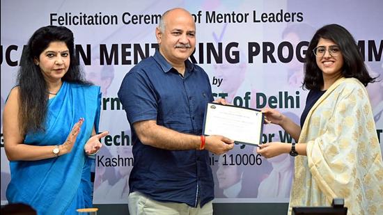 Delhi’s deputy chief minister Manish Sisodia felicitates a student of IGDTUW for successfully completing a six-month-long education mentoring programme, in New Delhi on Tuesday. (ANI)