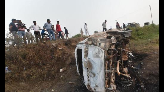 People take a look at the overturned SUV that was destroyed in violence during farmers’ protest, at Tikunia area of Lakhimpur Kheri district (PTI file photo)