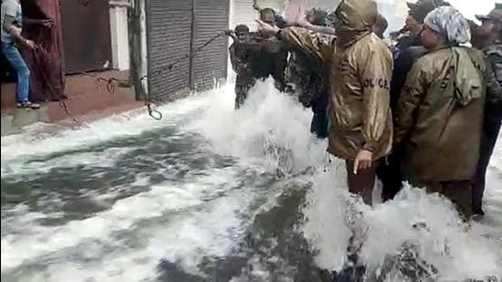 Police personnel and rescue teams evacuate locals stuck in their homes as Nainital Lake overflows and flooded the streets due to incessant rainfall, in Nainital on Tuesday. (ANI)