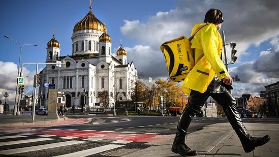 A food delivery courier walks in front of Christ the Saviour cathedral, the main Russian Orthodox church in central Moscow, on October 18, 2021, amid the outbreak of Covid-19, caused by the novel coronavirus.&nbsp;(AFP)