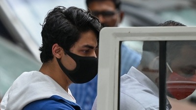 Aryan Khan is escorted to court by Narcotics Control Bureau officials for a bail plea hearing in Mumbai on October 8. (AFP Photo) Aryan Khan is escorted to court by Narcotics Control Bureau officials for a bail plea hearing in Mumbai on October 8. (AFP Photo)