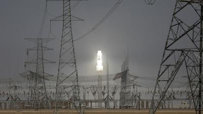 A molten salt solar tower stands behind electricity pylons at a power station near Dunhuang, Gansu province, China. By 2023, China will have the capacity to install solar power across the country at the same price as coal. (REUTERS)