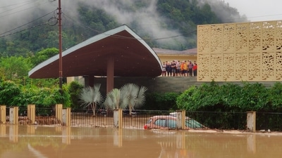 Hotel guests stand on the roof of a flooded hotel in Jim Corbett National Park, Uttarakhand as heavy rainfall battered the state. (HT_PRINT) Hotel guests stand on the roof of a flooded hotel in Jim Corbett National Park, Uttarakhand as heavy rainfall battered the state. (HT_PRINT)
