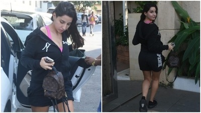 Nora opted for a simple all-black look for her outing in Mumbai. The star wore a black printed hooded jacket with a front zipper and teamed it with a pair of printed black shorts. (HT Photo/Varinder Chawla)
