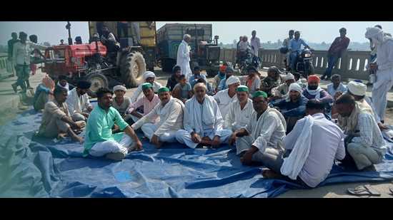Farmers sitting on a dharna in the middle of Shamli’s Bidauli bridge on UP-Haryana border. (HT Photo)