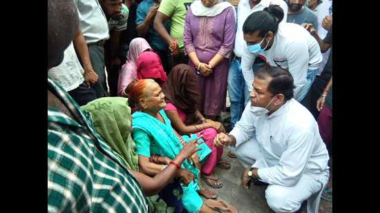 State vice president of Congress Upendra Singh talking to mother of Arun Kumar, who was accused of stealing ₹25 lakh from Jagdishpura police station in Agra and later died in police custody. (HT)