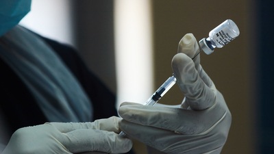 A health worker prepares a dose of the Pfizer-BioNTech Covid-19 vaccine. (Waldo Swiegers / BLOOMBERG)
