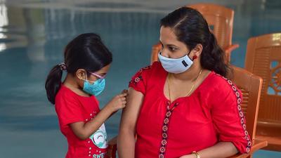 A child looks at her mother's hand after she received a dose of Covid-19 vaccine in Bengaluru on Thursday. Karnataka on Thursday reported 365 fresh Covid cases and 8 deaths. (PTI)