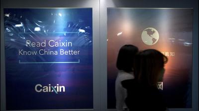 Staffers walk past a billboard ‘Read Caixin - Know China Better’ at the Caixin Media offices in Beijing. China has removed Caixin Media from a list of official news outlets that can be republished by other internet news providers. The new list has added mobile apps and China’s Twitter-like Weibo and WeChat social media accounts. (AP)