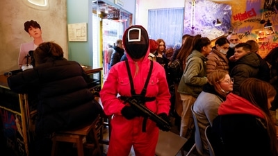 A waiter of Korean cafe Chick O'Rico poses for a picture in a costume of a personage from television series Squid Game in Moscow, Russia. (REUTERS)