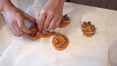 A customer puts shape templates onto circles of biscuit mix during a session of a South Korean Netflix show Squid Game-themed confection-making event, at a bakery in Beijing, China. (REUTERS)