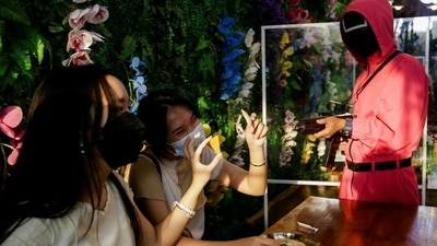 Customers play Squid Game's honeycomb toffee game at Strawberry Cafe in Jakarta, Indonesia. (REUTERS)