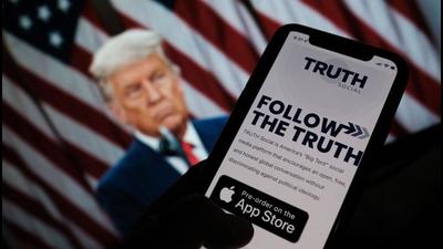 This illustration photo shows a person checking the app store on a smartphone for ‘Truth Social’, with a photo of former US president Donald Trump on a computer screen in the background, in Los Angeles. (AFP) This illustration photo shows a person checking the app store on a smartphone for ‘Truth Social’, with a photo of former US president Donald Trump on a computer screen in the background, in Los Angeles. (AFP)