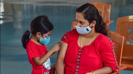A child looks at her mother's hand after she received a dose of Covid-19 vaccine in Bengaluru on Thursday. Karnataka on Thursday reported 365 fresh Covid cases and 8 deaths. (PTI)