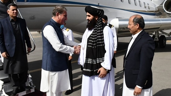 Afghanistan's acting Foreign Minister Amir Khan Muttaqi (2R) receiving Pakistan's Foreign Minister Shah Mahmood Qureshi (3L) upon his arrival at the airport in Kabul.&nbsp;(AFP)