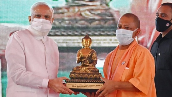 Uttar Pradesh Chief Minister Yogi Adityanath gifts the statue of Gautam Buddha to Prime Minister Narendra Modi at the inauguration and foundation stone laying ceremony of various development projects, in Kushinagar on October 20.(ANI)