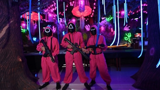 Waiters dressed in outfits from the Netflix series Squid Game pose while playing a game to attract customers at a cafe in Jakarta.(AFP)
